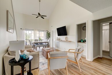 Living room featuring ceiling fan, high vaulted ce