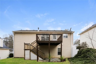 Back of property with stairway, a lawn, and a wood