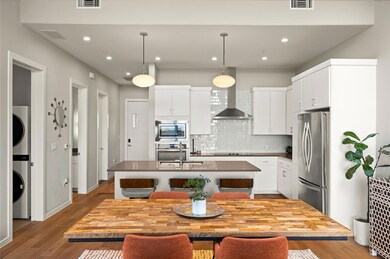 Kitchen featuring wall chimney range hood, applia
