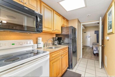 Kitchen with sink, a textured ceiling, black appli