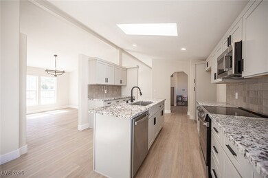 Kitchen with light wood finished floors, a sink, l
