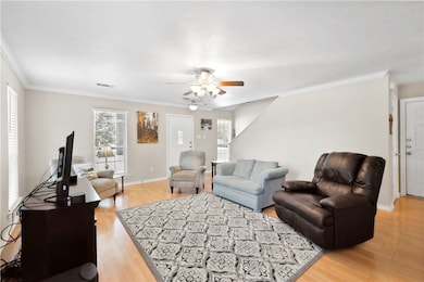 Living area featuring a ceiling fan, ornamental mo