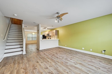 Unfurnished living room with ceiling fan, wood fi