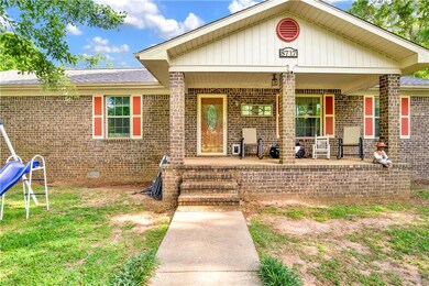 Entrance to property with covered porch, brick siding, crawl space, and roof with shingles