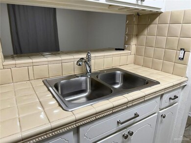 Kitchen featuring tile counters and tasteful backsplash