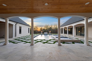 Patio terrace at dusk with an outdoor pool and an 