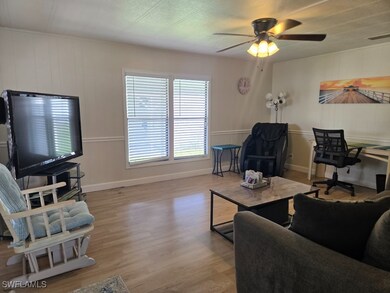 Living room featuring ceiling fan and light hardwo