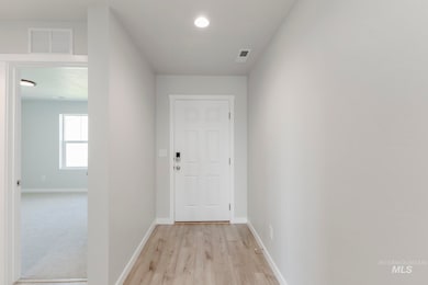 Doorway to outside with wood finished floors and recessed lighting