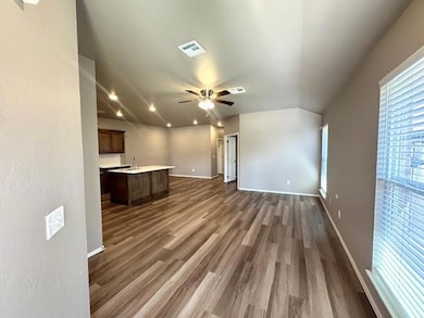 Unfurnished living room featuring a ceiling fan, dark wood finished floors, baseboards, and recessed lighting