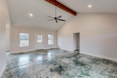Unfurnished living room with baseboards, ceiling f