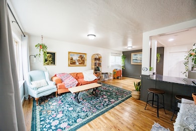 Living room with light wood-type flooring and a textured ceiling