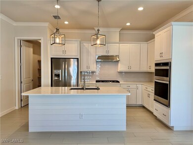 Kitchen featuring sink, an island with sink, white