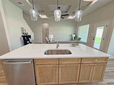 Kitchen with coffered ceiling, dishwasher, a sink,