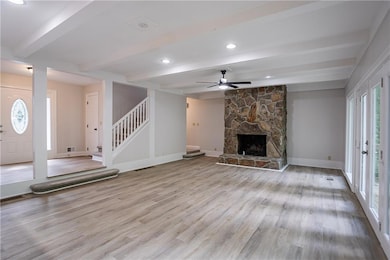 Unfurnished living room featuring beamed ceiling, 