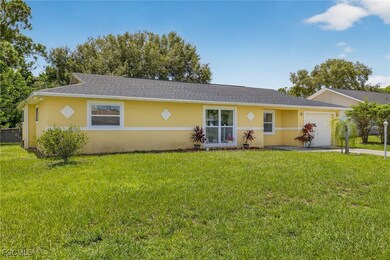 Ranch-style home featuring stucco siding, a garage, a front yard, and roof with shingles