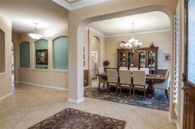 Tiled dining room with crown molding and a notable
