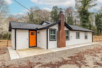 View of front of house with a patio, roof with shi