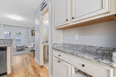 Kitchen with crown molding, light hardwood / wood-