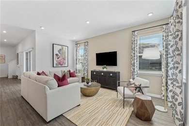 Living room with wood finished floors, healthy amount of natural light, and recessed lighting