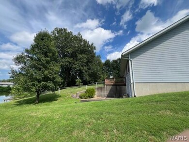 View of grassy yard featuring a deck with water view