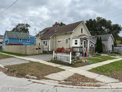 Bungalow-style home with a fenced front yard and a chimney