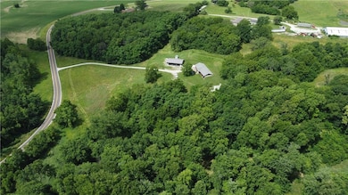 Aerial view of property and surrounding area featuring a heavily wooded area