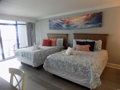 Bedroom with wood finished floors and access to outside