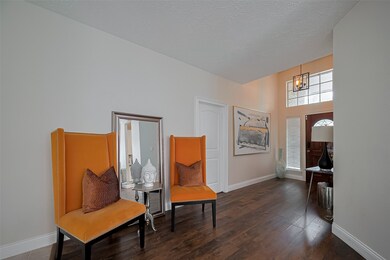 Bright entryway with high ceilings. The space is complemented by hardwood floors and ample natural light from a window above the door.
