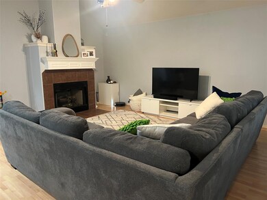 Living room featuring a ceiling fan, wood finishe
