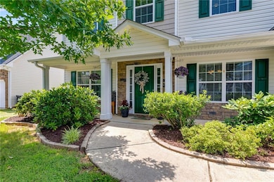 Doorway to property with a porch, stone siding, and an attached garage