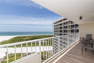 Balcony featuring a view of the beach and a water view