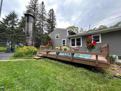 Back of property with a chimney, a lawn, and a wooden deck