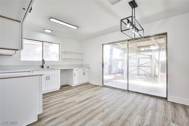 Kitchen with white cabinetry, light wood finished floors, hanging light fixtures, and open shelves