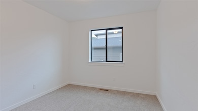 Spare room featuring light colored carpet and a textured wall