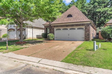 View of front of house featuring a shingled roof, concrete driveway, a front yard, and brick siding