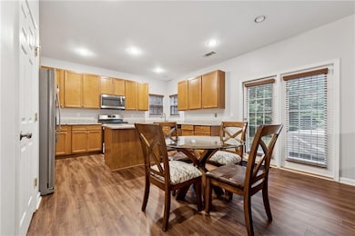 Dining area with dark wood finished floors and recessed lighting