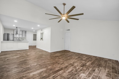 Unfurnished living room with recessed lighting, dark wood-style floors, high vaulted ceiling, and a ceiling fan