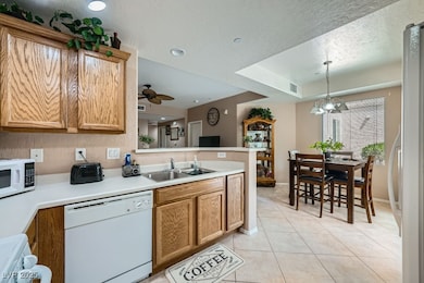 Kitchen with white appliances, a peninsula, light