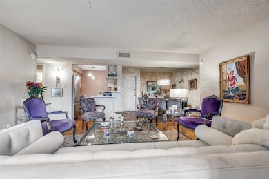 Living area with wood finished floors and a textured ceiling