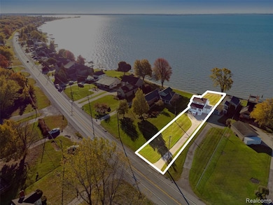 Aerial view of residential area with a nearby body of water and property boundaries highlighted