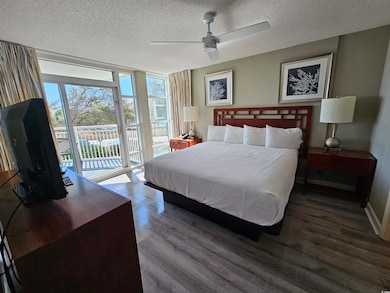 Bedroom with a textured ceiling, access to outside