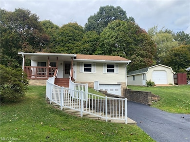 View of front of house with a garage, covered porch, and a front yard