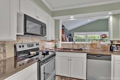 Kitchen featuring dark stone countertops, sink, wh