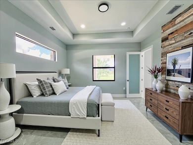 Bedroom with a tray ceiling and recessed lighting