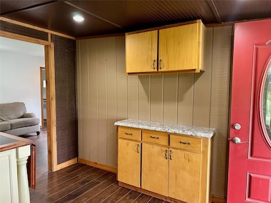 Kitchen with dark wood finished floors, wooden wa