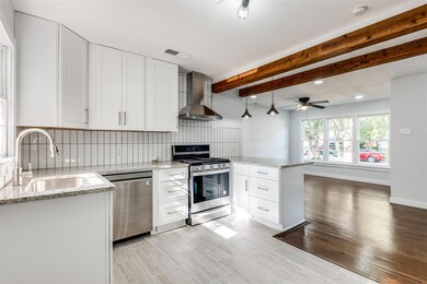Kitchen overlooks dining and living areas and is accented by pendant lighting above the counter