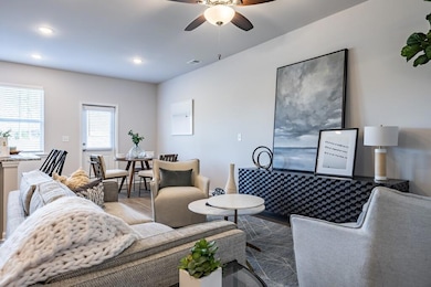 Living room featuring ceiling fan and dark wood-type flooring
