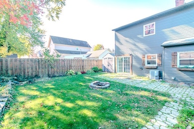 Fenced backyard featuring a shed and a fire pit