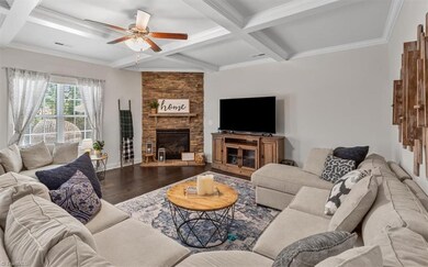 Spacious living room with coffered ceiings, gas logs and ceiling fan.