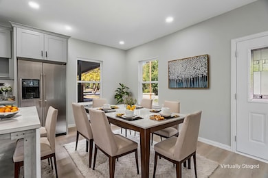 Dining room with light wood finished floors, plenty of natural light, and recessed lighting